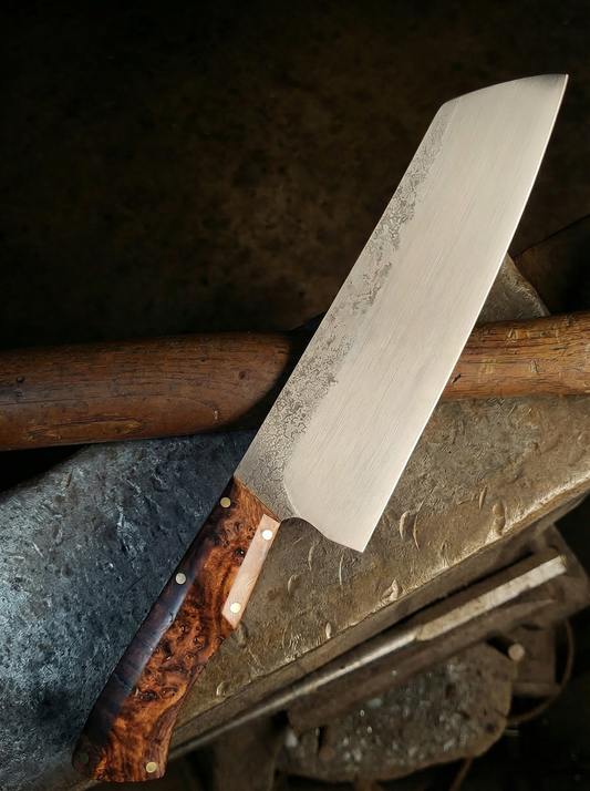 Handcrafted knife with a wooden handle on a metal surface